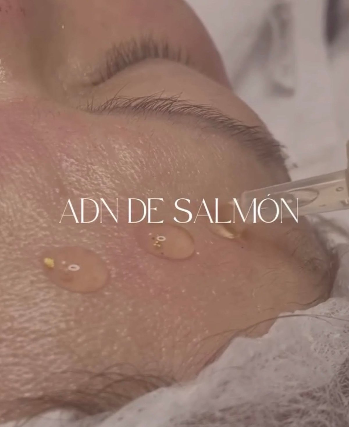 Close-up of skincare application on cheek with text ADN DE SALMON overlaid on beauty treatment image