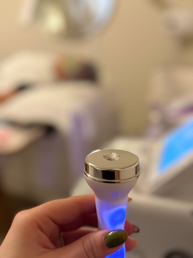 Hand holding a small bottle with blue LED light and silver metallic cap in a kitchen setting