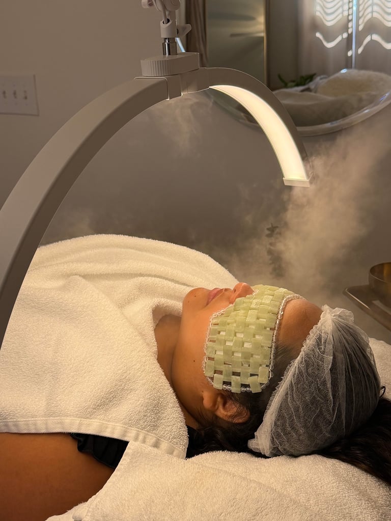 Person receiving facial treatment under a professional steam or spa machine with warm mist